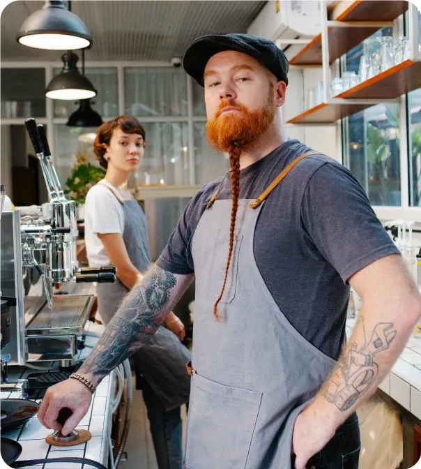 barista's stood behind the counter in a coffee shop